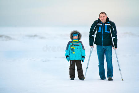 拄着拐杖的男人和他儿子在户外散步