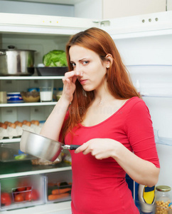 冰箱附近有肮脏食物的女人