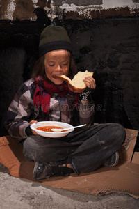 无家可归的小男孩在街上吃饭
