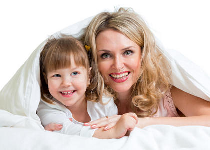 快乐的母亲和孩子躺在毯子下面