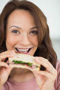 一个女人吃三明治的特写照片