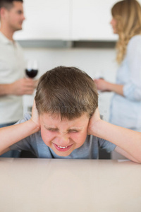 父母争吵时，愤怒的男孩捂着耳朵