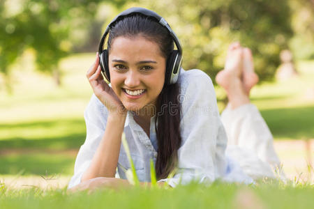 快乐的年轻女子在公园里欣赏音乐