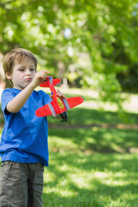 公园里带玩具飞机的可爱男孩