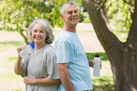 带着水瓶在公园里微笑的成熟夫妇