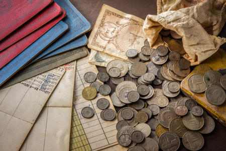 在胸部的旧硬币在肮脏的背景下的旧硬币和银行存折.照片