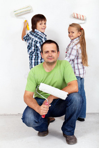 孩子们和他们的父亲在粉刷房间