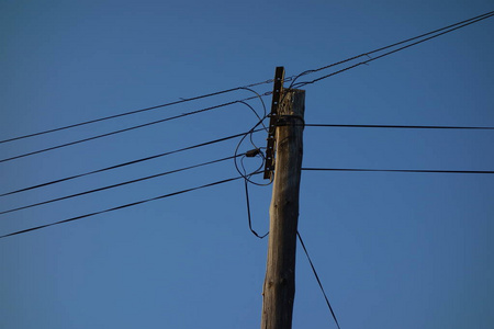 蓝天上的电线杆和电缆照片