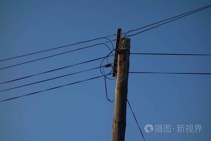 蓝天上的电线杆和电缆