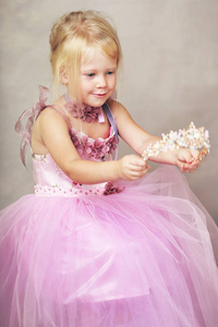 美丽的小公主，穿着玫瑰色的粉红色长袍，戴着水晶皇冠