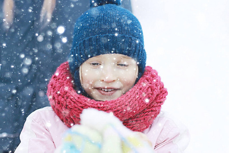 白雪皑皑的冬天公园里可爱的小女孩，一个穿暖和衣服的孩子的季节性照片