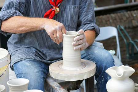 s hands make a clay pitcher, macro. Potter makes a pitcher.