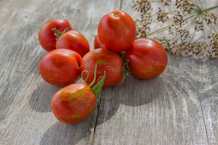 新鲜的红色大西红柿在阳光明媚的一天在木桌上。 美味的食物。 素食概念。