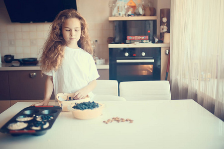 可爱的小女孩在厨房烤蓝莓派