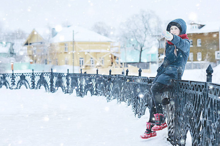 白雪皑皑的冬天公园里可爱的小女孩，一个穿暖和衣服的孩子的季节性照片