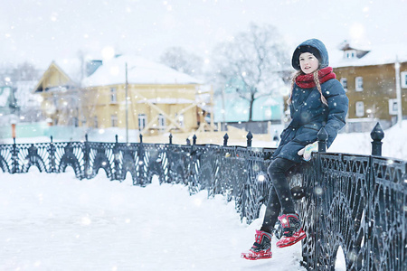 白雪皑皑的冬天公园里可爱的小女孩，一个穿暖和衣服的孩子的季节性照片