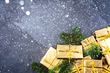 圣诞背景。 石板背景上的金色礼盒。 平躺顶部视图。