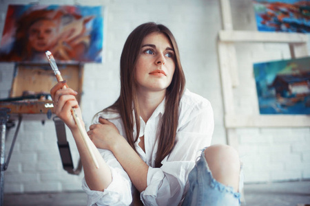 年轻漂亮的女艺术家，在车间里刷油漆