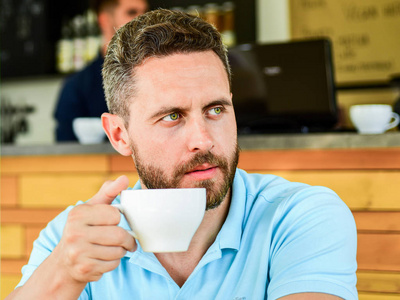 人胡子严肃的面孔需要能量充电。传统咖啡打破咖啡馆的背景。能让你精力充沛。认真的家伙享受饮料关闭。开始一天大杯咖啡