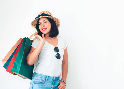 亚洲女人的肖像持有许多购物袋，摆在孤立的白色背景上。