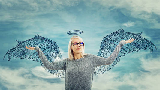 骄傲的年轻女子举起双手,感到强大和成功,想象自己是一个天使与翅膀和