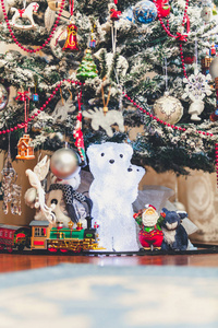 圣诞树下的玩具发光的北极熊的身影，熊站在装饰好的圣诞树前。 圣塔劳附近