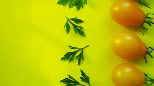 黄色背景的小番茄和欧芹。