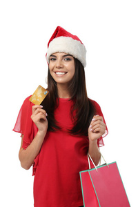 戴着圣诞帽的年轻女子，戴着信用卡和白色背景的购物袋