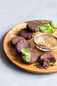 巧克力饼干，巧克力薄荷和可可粉在木切割板上。