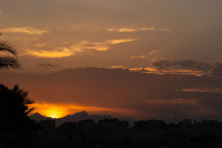 日落在城市的赫尔格达与建筑物和山脉剪影