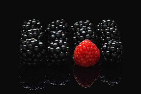 黑桌上的黑莓和覆盆子与其他不同