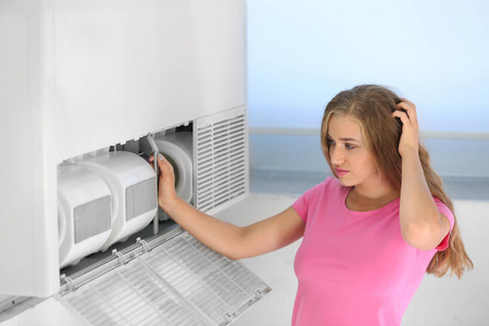 年轻女子在家修理空调