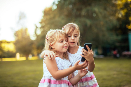 孩子们喜欢在公园里使用智能手机。