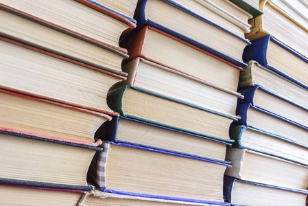 文字堆积书堆旧书,背景书,不同厚度和颜色,许多书堆在学校图书馆,旧书