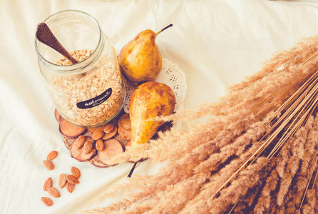 健康素食的原料与苹果和梨紧密地结合在白色亚麻桌布上。 水平白色乡村风格。 健康的早餐概念。 上面的风景。