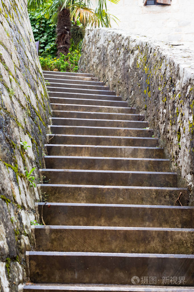 弯曲的石头楼梯部分覆盖着黑色苔藓