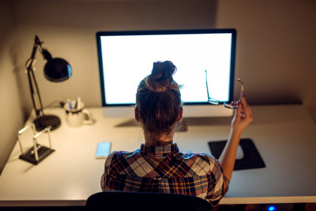 程序员加班一个年轻的女商人在电脑上加班.照片