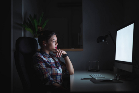 年轻成功的女商人深夜在家工作,照片