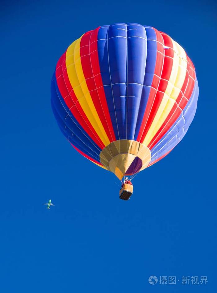 明亮的多色气球在晴朗的蓝天的背景下随着太阳的照射而发光