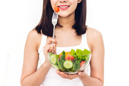 快乐的女人在碗里吃着健康的新鲜沙拉。饮食观念。绿色食物的健康生活方式