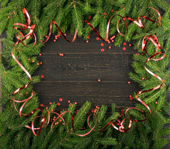 圣诞节背景与冷杉枝在老式的木制背景平躺和顶部视图。 圣诞花架装饰与复制空间。 创意圣诞树边界新年贺卡