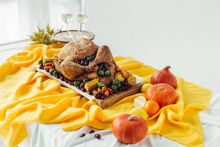 近观节日感恩节餐桌，桌上摆着一杯葡萄酒烤火鸡和蔬菜，桌上摆着桌布