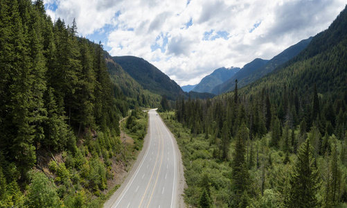 鸟瞰一条风景优美的道路穿过山谷，周围是美丽的加拿大山脉。 位于希望和加拿大普林斯顿之间。