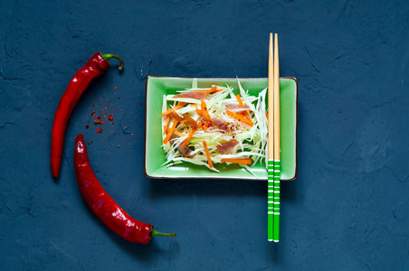 卷心菜沙拉卷心菜和牛肉在绿色陶瓷盘与筷子在蓝色背景混凝土, 隔绝, 有机食物概念, 排毒食物或素食概念。顶部视图, 复制空间, 