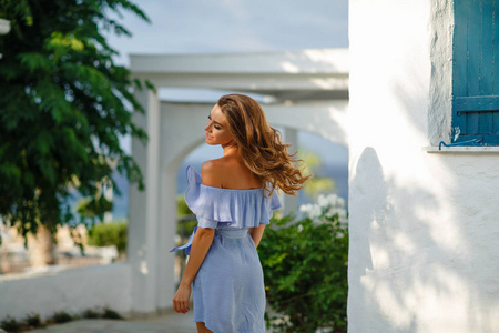 夏天，穿着蓝色连衣裙在花园里的大海上旋转，非常美丽和的女孩