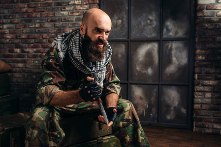 穿制服的手里拿着刀坐在弹药箱里.