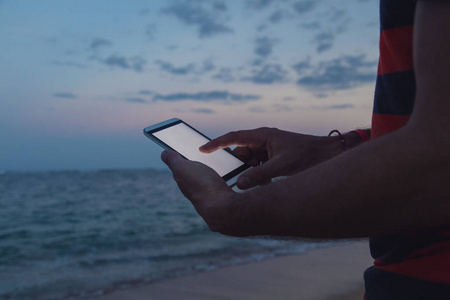 在热带异国海滩上用手机的人。