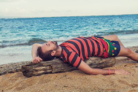 男人在空荡荡的热带异国海滩上享受。