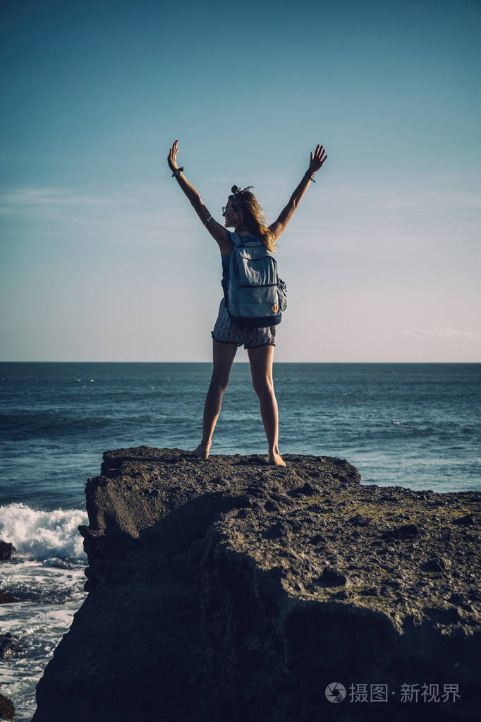 女孩张开双臂享受海洋.