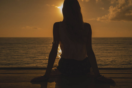 女孩享受海洋热带日落日出。